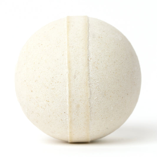Round, cream-colored Cleopatra bath bomb with a textured oatmeal finish and a smooth center band on a white background.