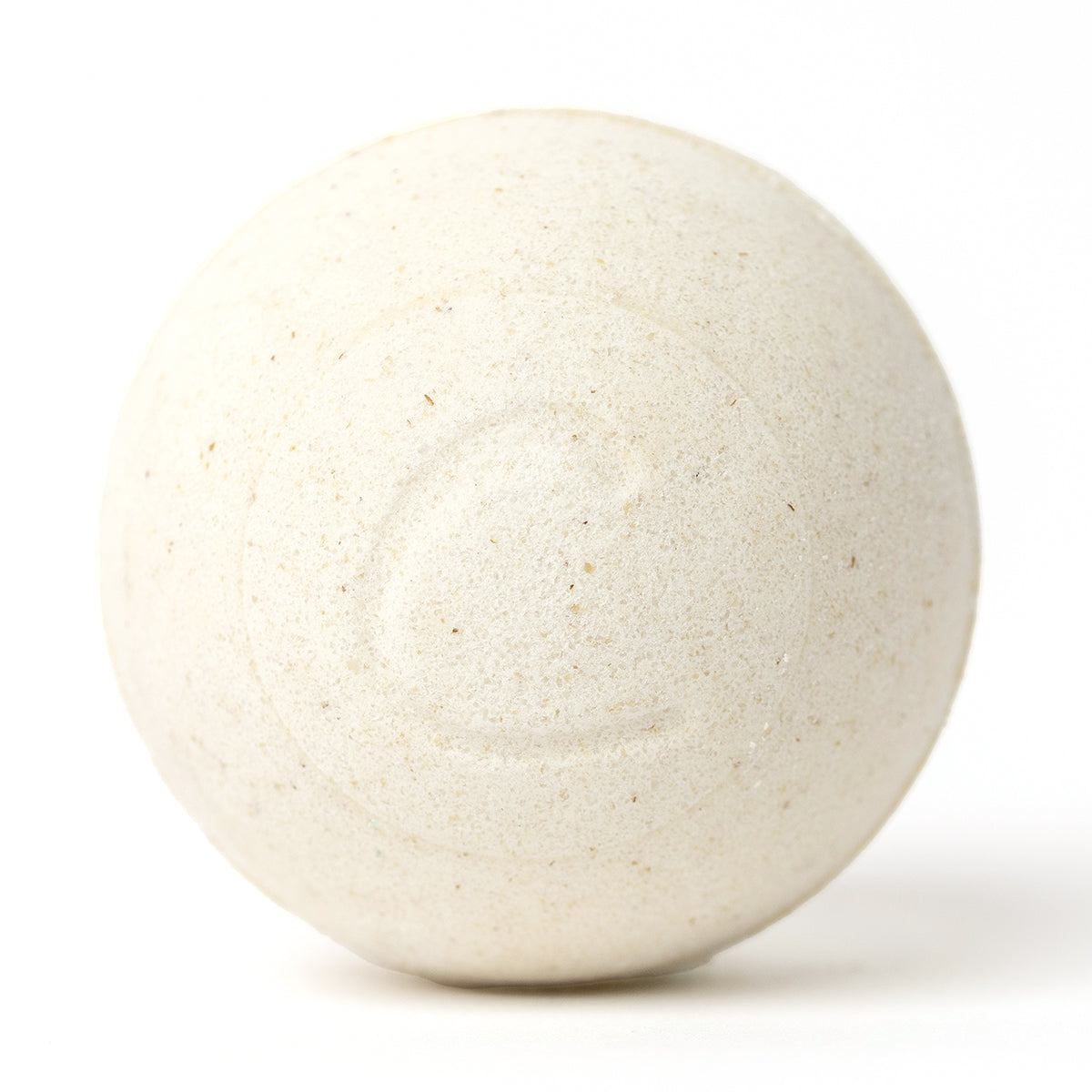 Round, cream-colored oatmeal bath bomb with a textured, speckled surface and a subtle embossed letter C on a white background.