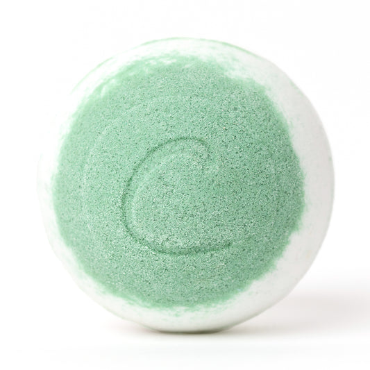 Round white and lime green bath bomb with a textured surface and a subtle letter C embossed on the front.